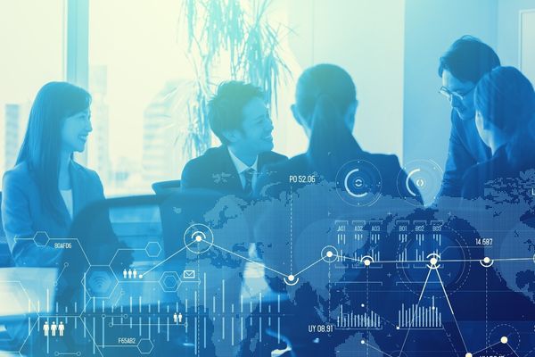 Group of professionals in a modern office discussing with a translucent digital data and world map overlay illustrating analytics